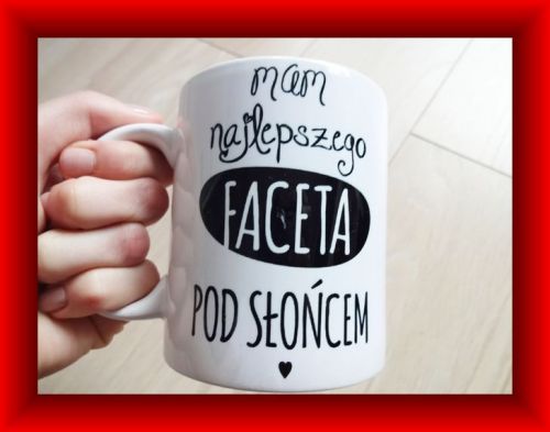Bia�y kubek z napisem Mam najlepszego faceta pod s�o�cem trzymany w d�oni