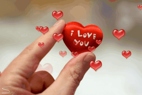D�o� trzyma czerwone serce z napisem I love you i unosz�cymi si� wok� mniejszymi serduszkami