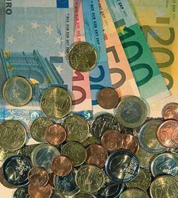 Kolorowe banknoty euro oraz rozsypane na nich monety o różnych nominałach