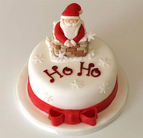 Bia�y tort bo�onarodzeniowy z Miko�ajem w kominie, p�atkami �niegu i napisem Ho Ho
