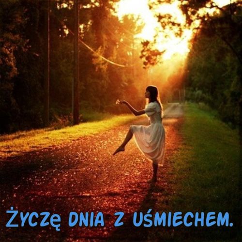 Kobieta w białej sukni tańcząca na leśnej drodze w blasku zachodzącego słońca, napis Życzę dnia z uśmiechem