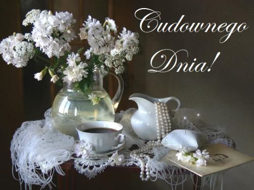 Bia�e kwiaty w szklanym wazonie, fili�anka kawy, per�y i napis Cudownego Dnia na stoliku