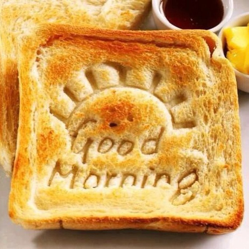 Z�ocisty tost z wyt�oczonym s�o�cem i napisem Good Morning, miodem oraz mas�em