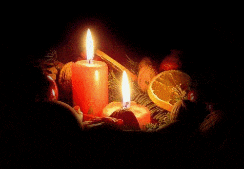 Dwie pal�ce si� �wiece w otoczeniu ga��zek �wierku, suszonych pomara�czy, orzech�w i cynamonu