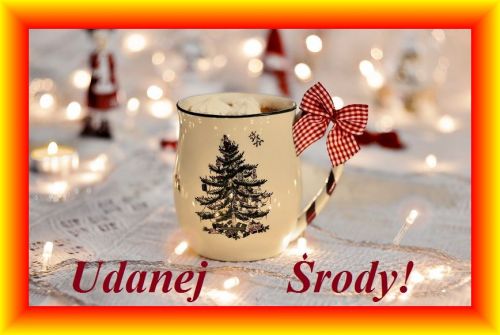 Kubek z motywem choinki, kokardą i napisem Udanej Środy na tle lampek