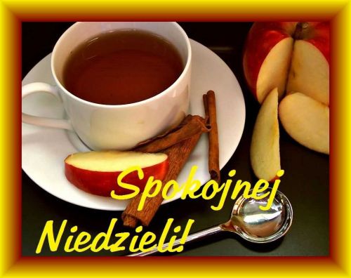 Biała filiżanka herbaty z cynamonem i plasterkami jabłka na talerzyku z napisem Spokojnej Niedzieli